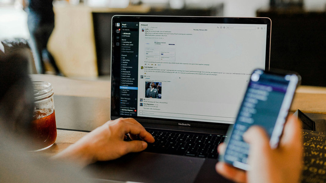 Customer service representative resolving a dispute using a laptop and smartphone, emphasizing efficient communication and prompt resolution for customer satisfaction.