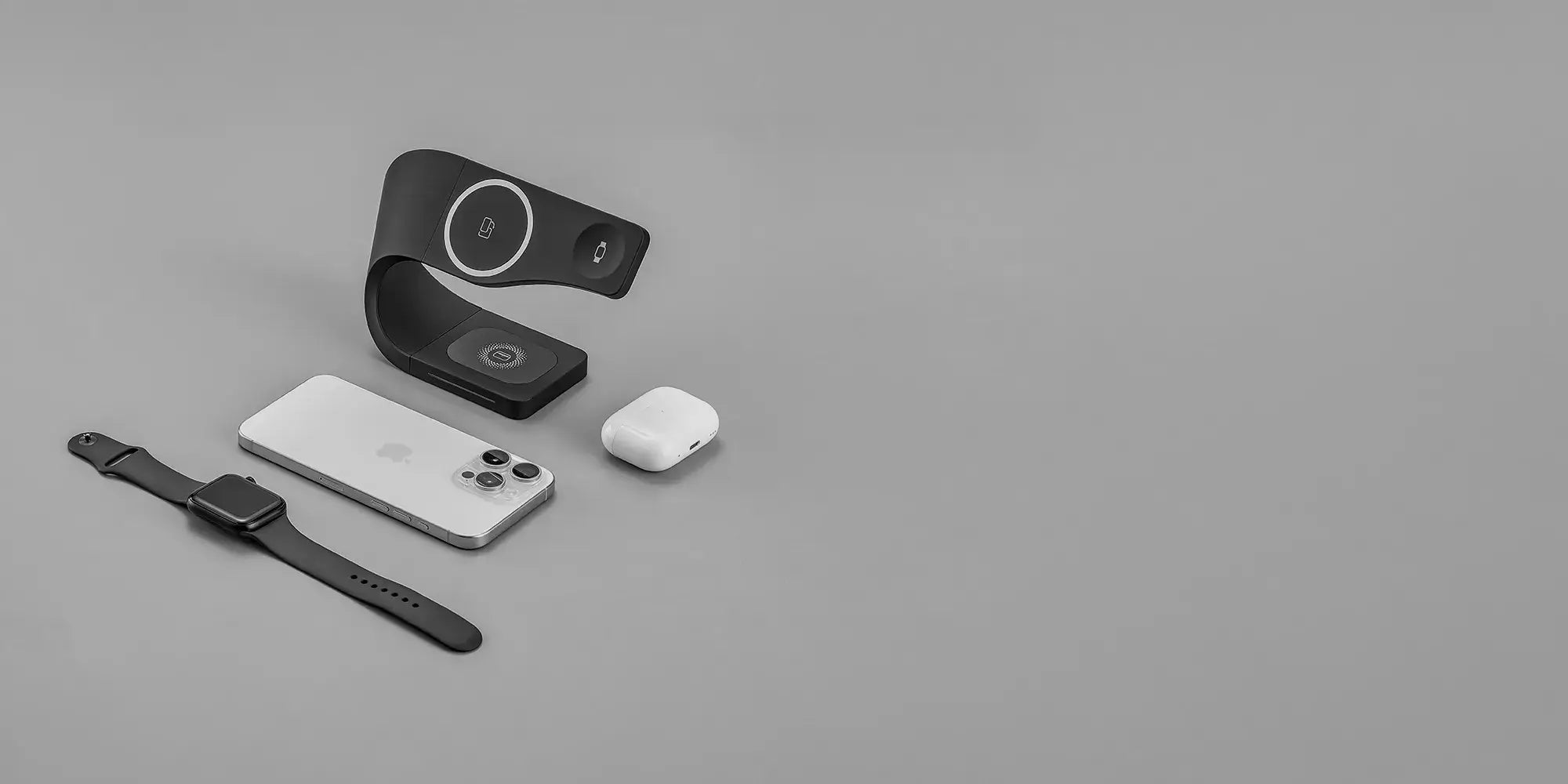 Simpli MagSafe charging stand in black charging Apple devices: iPhone, Apple Watch, and AirPods on a sleek desk