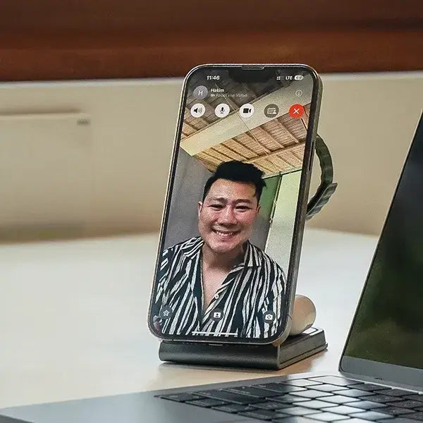 Magnitis MagSafe charging stand holding iPhone on video call perfect angle beside laptop on desk