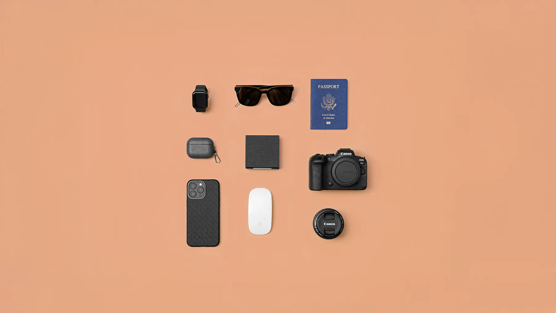 Flat lay of travel essentials featuring Modern Standard’s Cubica MagSafe 3-in-1 travel charger, iPhone case, camera, and passport.