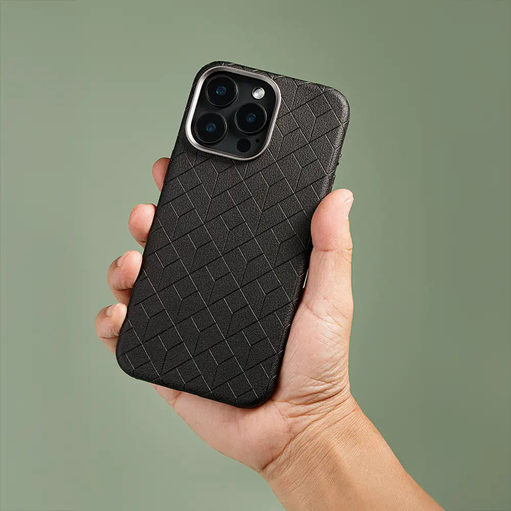 Hand holding the Essentia Case in Ebony with a geometric textured pattern, non-slip design, and MagSafe-compatible features.