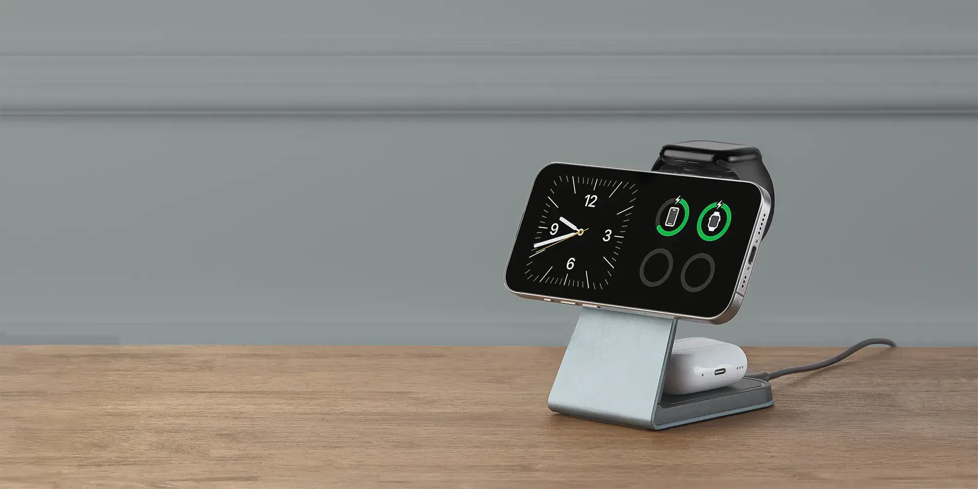 Slate gray Magnitis MagSafe charging stand in StandBy Mode showing iPhone clock and battery status with Apple Watch and AirPods charging
